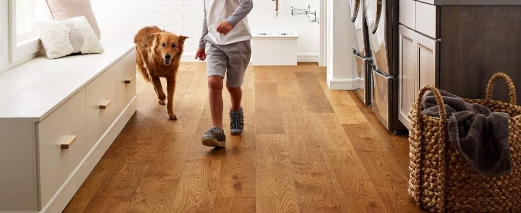 Boy and dog running on hardwood floor | MyNewFloor.com